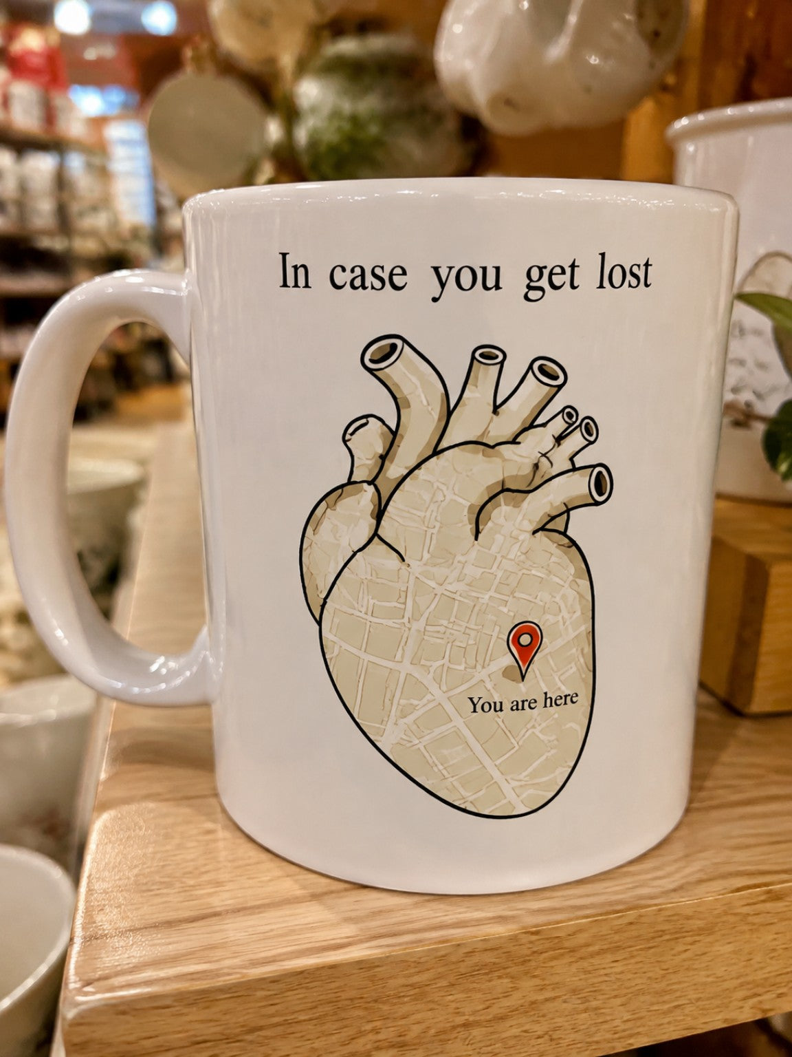 White ceramic heart map mug reading In case you get lost, You are here