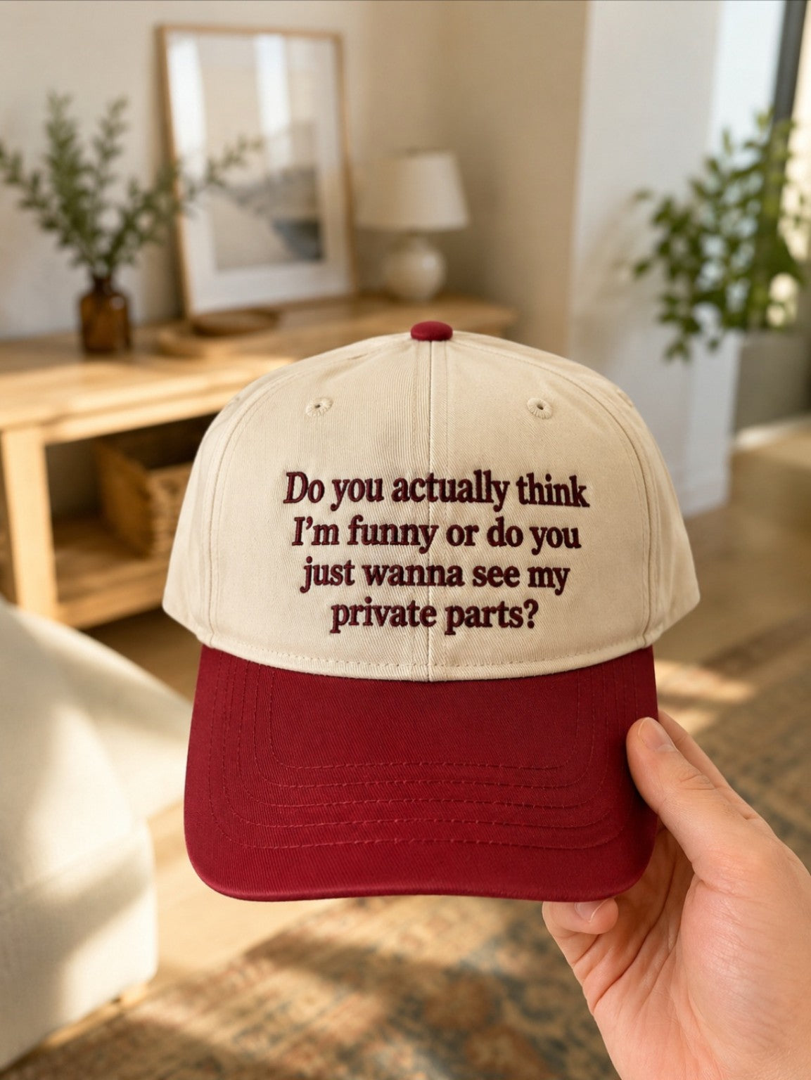 Cream and burgundy cap embroidered with a funny adult-humour slogan