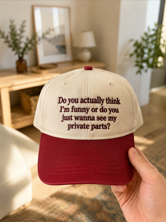Cream and burgundy cap embroidered with a funny adult-humour slogan